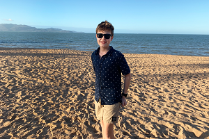 A boy standing on sand with the sea behind him. A clip from the Eureka Prize winning film.